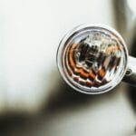 Zbliżenie na metaliczny kierunkowskaz motocykla z włączoną żarówką