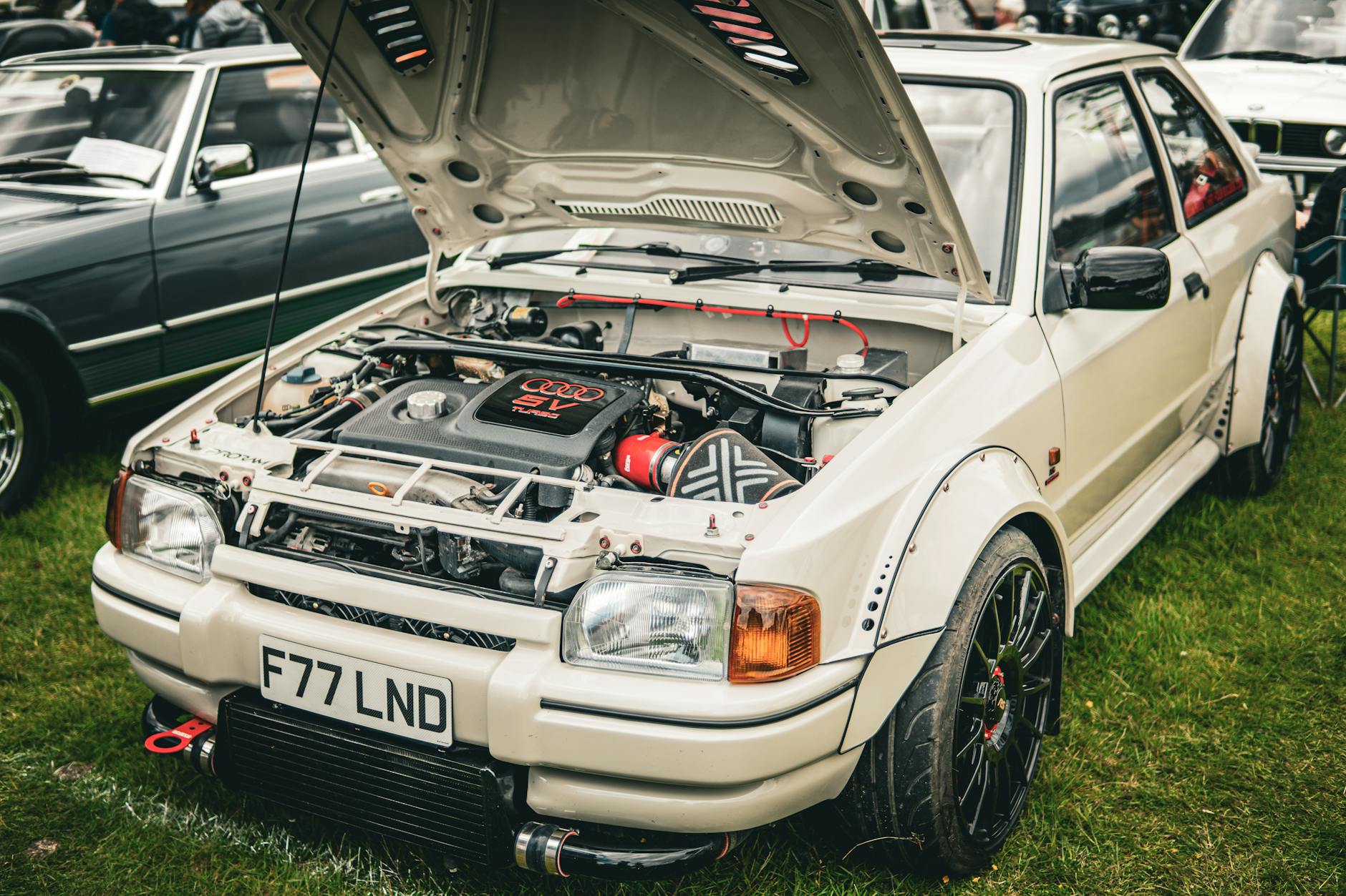 Zmodyfikowany samochód rajdowy z otwartą maską na zlocie tunerów