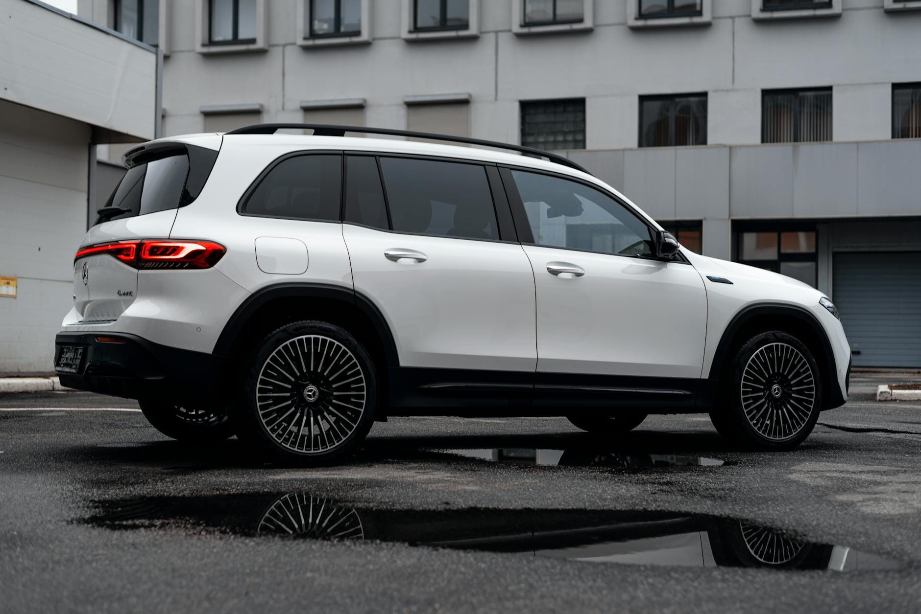 Biały Mercedes-Benz EQB widziany z boku, zaparkowany w mieście