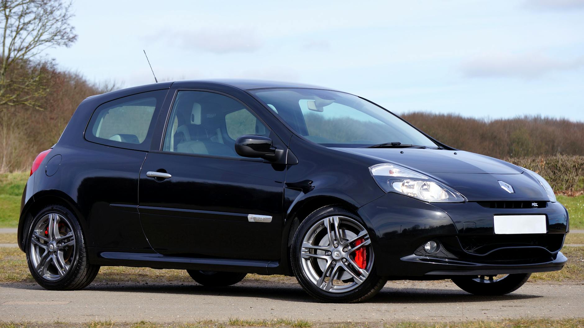 Czarne Renault Clio RS zaparkowane w malowniczym plenerze