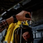 Mechanik śrubokrętem sprawdza silnik auta Opel Insignia