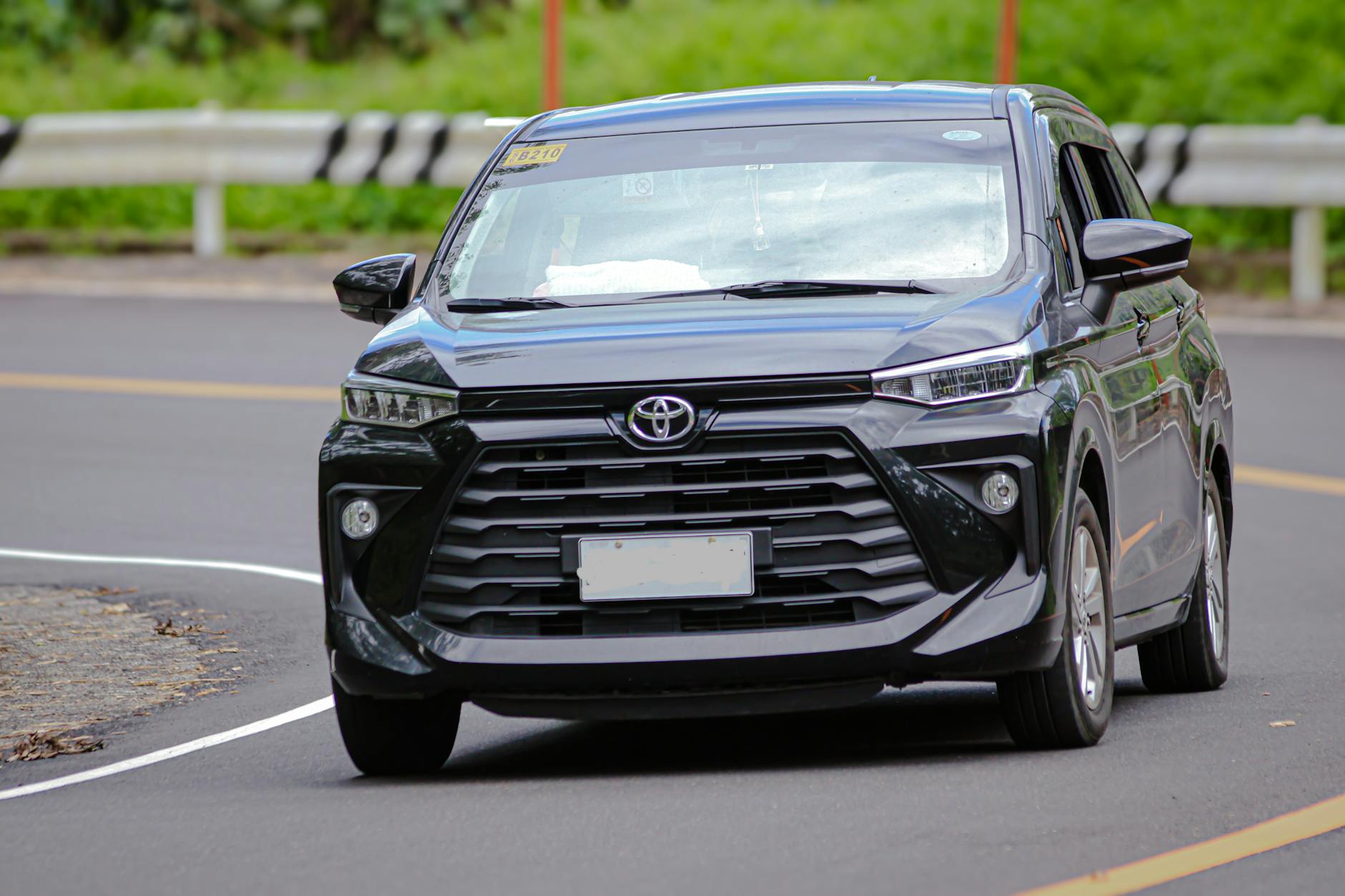 Czarny Opel Zafira Tourer jedzie po miejskiej ulicy za dnia