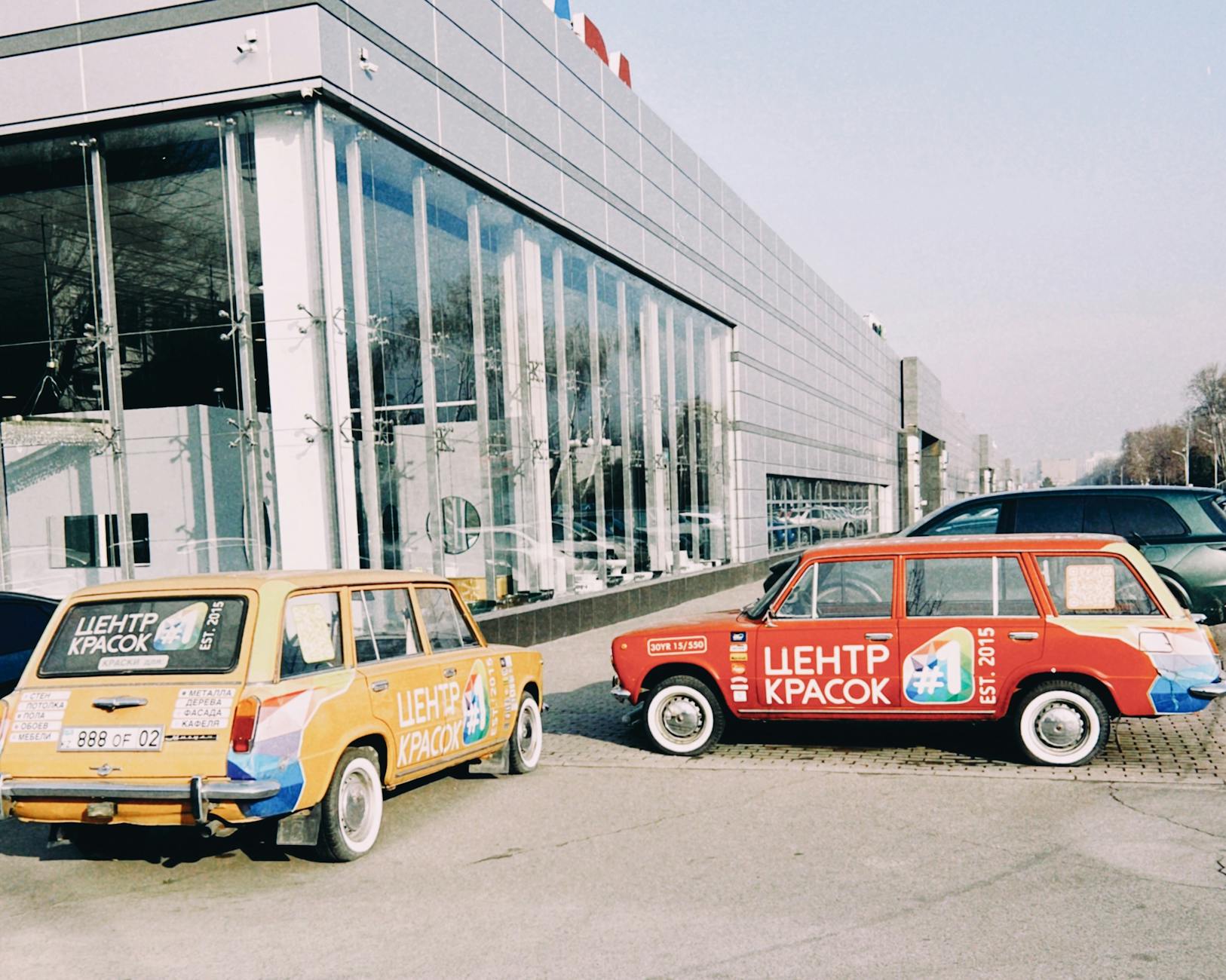 Kolorowe klasyczne auta przed szklanym biurowcem w Ałmaty Kolorowe klasyczne auta przed szklanym biurowcem w Ałmaty