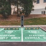 Opel Corsa Electric: ile kosztuje ładowanie w domu i na publicznych stacjach? Zielony Opel Corsa Electric podłączony do ładowarki w mieście